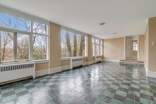 interior space with radiator heating unit, visible vents, and baseboards