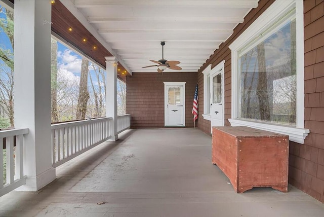 exterior space featuring beamed ceiling and a ceiling fan