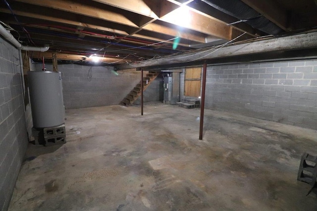 unfinished below grade area featuring gas water heater and stairway