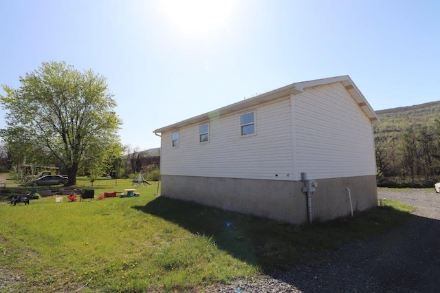 view of side of home with a yard