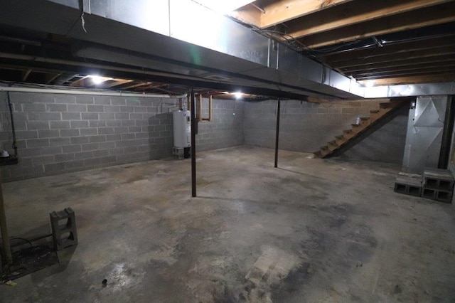 unfinished basement with water heater and stairway
