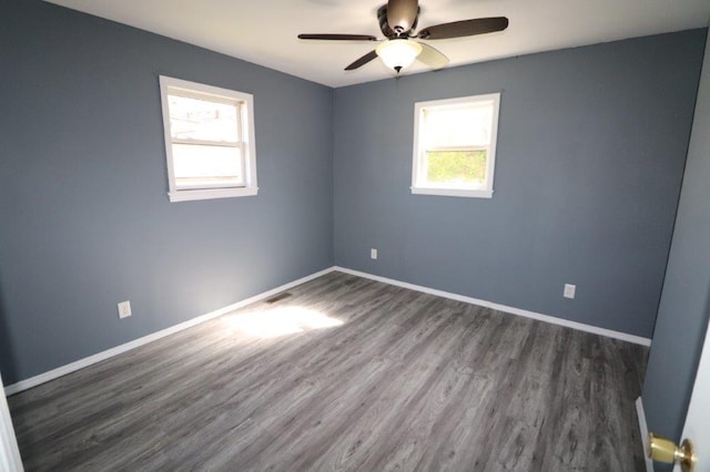 spare room featuring ceiling fan, wood finished floors, and a wealth of natural light