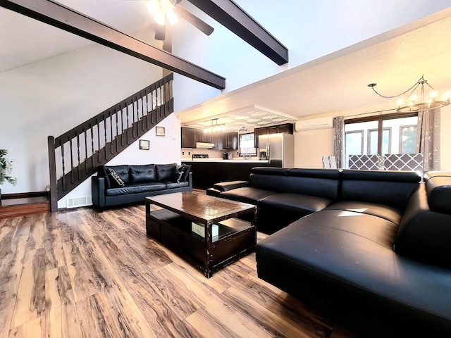 157 Seminole Trl, Tobyhanna, PA 18466 - living area with stairway, a chandelier, light wood-style floors, ceiling fan, and an AC wall unit