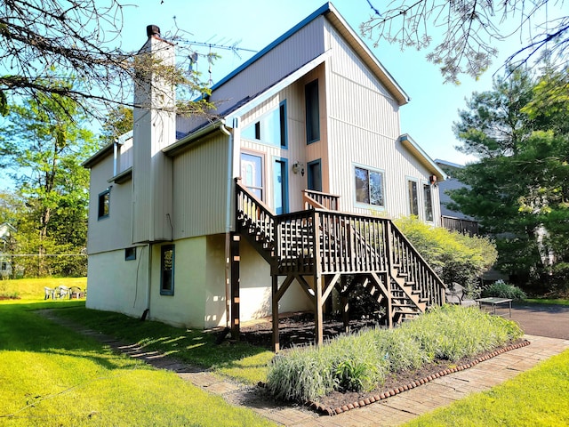 157 Seminole Trl, Tobyhanna, PA 18466 - rear view of property featuring stairway, a yard, a chimney, and a wooden deck