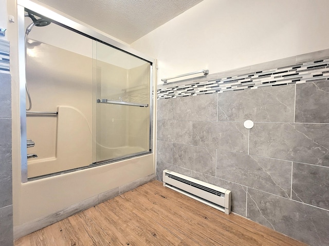 157 Seminole Trl, Tobyhanna, PA 18466 - bathroom featuring baseboard heating, combined bath / shower with glass door, wood finished floors, and a textured ceiling