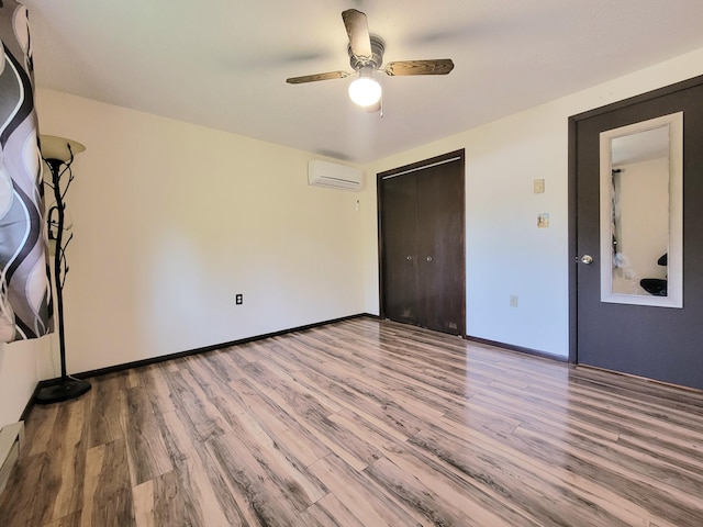 157 Seminole Trl, Tobyhanna, PA 18466 - unfurnished bedroom with a wall mounted AC, wood finished floors, a closet, baseboards, and ceiling fan