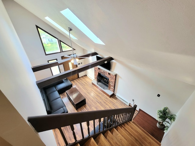 157 Seminole Trl, Tobyhanna, PA 18466 - stairs with a skylight, wood finished floors, a fireplace, vaulted ceiling, and ceiling fan