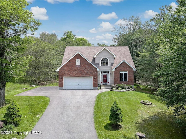 traditional home with aphalt driveway, brick siding, a garage, and a front yard