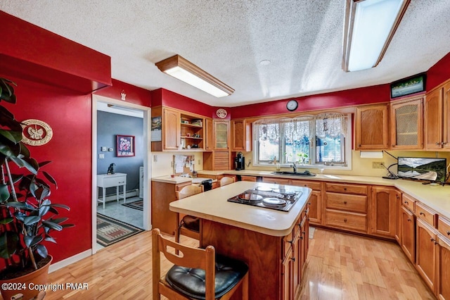 kitchen featuring a breakfast bar, light countertops, light wood-type flooring, and electric stovetop