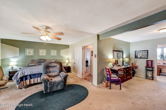 carpeted bedroom with a textured ceiling, ceiling fan, beam ceiling, and baseboards