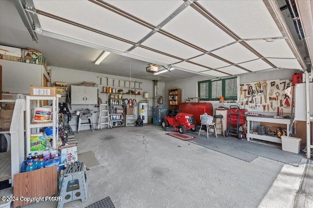 garage featuring water heater, a workshop area, and a garage door opener