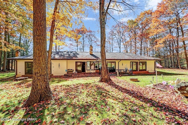 rear view of house with a lawn and a chimney