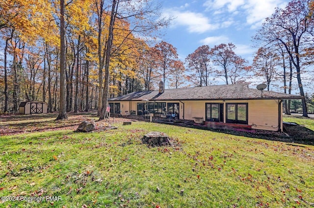 view of front of house featuring a front yard, an outdoor structure, and a shed