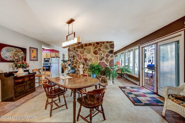 dining room featuring a baseboard heating unit and light carpet