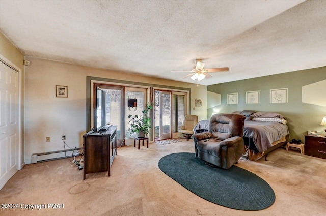 bedroom with a baseboard heating unit, light colored carpet, ceiling fan, and a textured ceiling