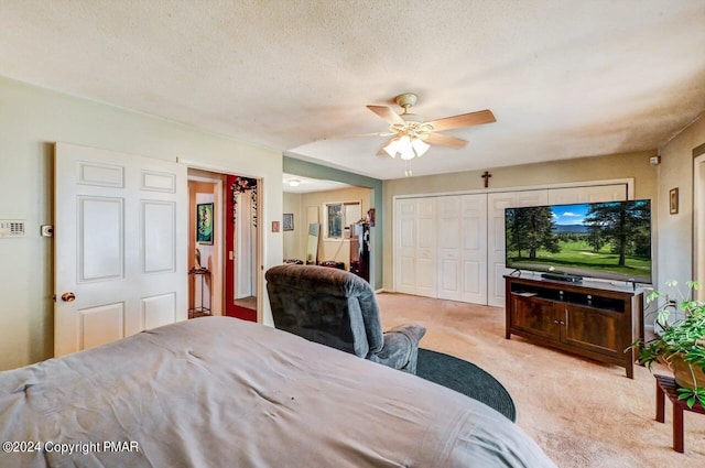 bedroom featuring a textured ceiling, carpet, and a ceiling fan