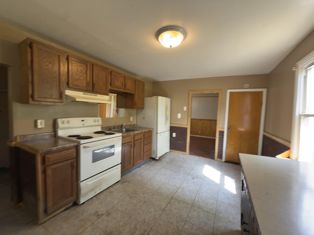 80 Parsonage St Rear, Rear, Pittston, PA 18640 - kitchen featuring white appliances, under cabinet range hood, brown cabinets, a wainscoted wall, and a sink