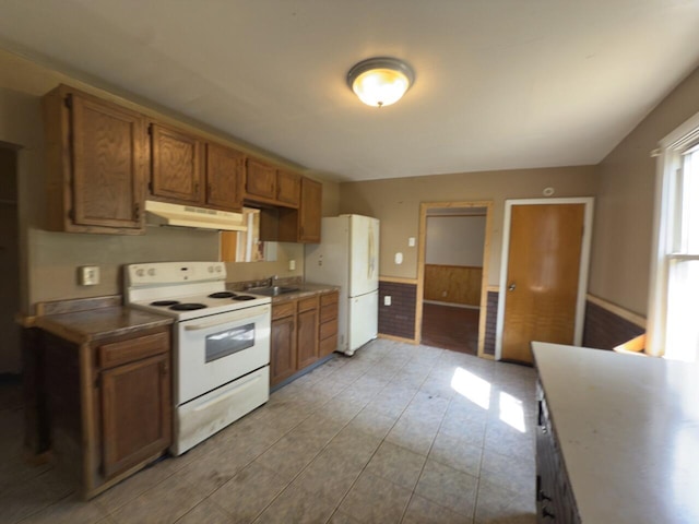 80 Parsonage St Rear, Rear, Pittston, PA 18640 - kitchen featuring white appliances, under cabinet range hood, brown cabinets, a wainscoted wall, and wooden walls