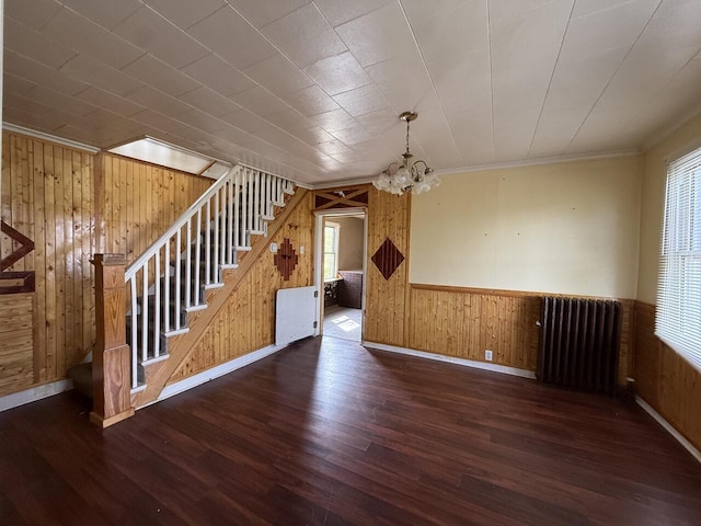 80 Parsonage St Rear, Rear, Pittston, PA 18640 - unfurnished living room featuring radiator, wood walls, wood finished floors, stairway, and a chandelier