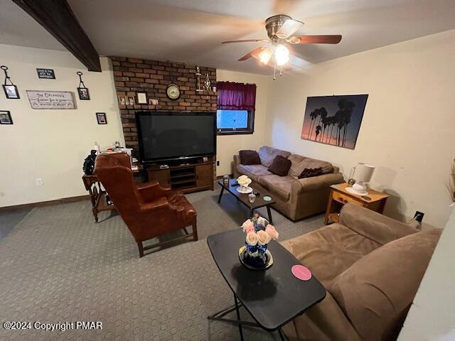 living area with ceiling fan, carpet floors, beam ceiling, and baseboards