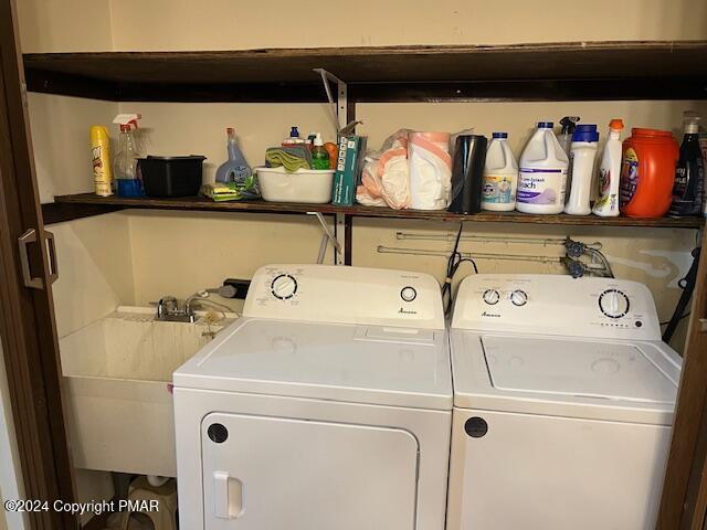 clothes washing area with a sink, laundry area, and washing machine and dryer