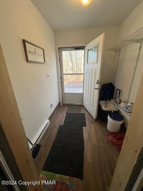 doorway with a baseboard radiator and wood finish floors