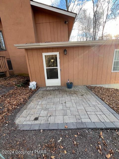 view of exterior entry featuring a patio area