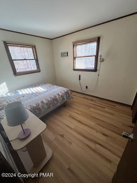 unfurnished bedroom featuring ornamental molding and light wood finished floors