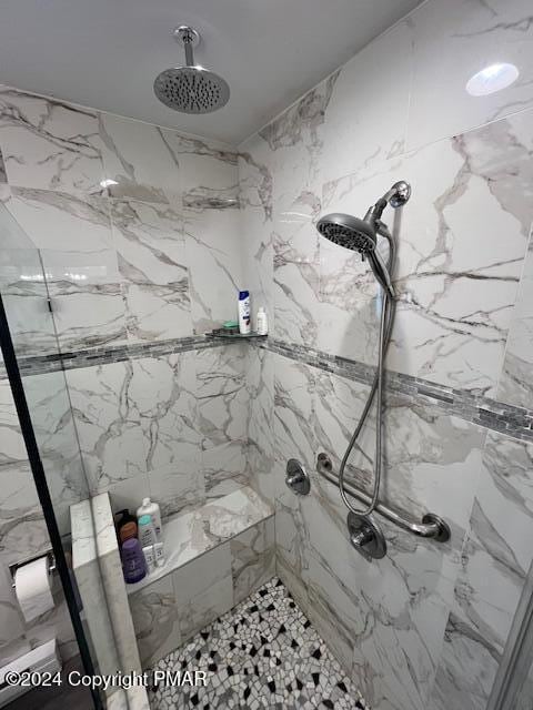 bathroom with a marble finish shower