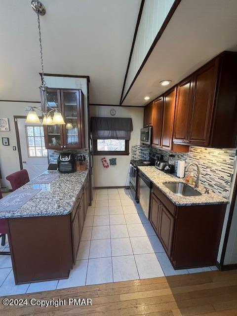 kitchen featuring tasteful backsplash, stainless steel microwave, a sink, black range with electric cooktop, and a peninsula