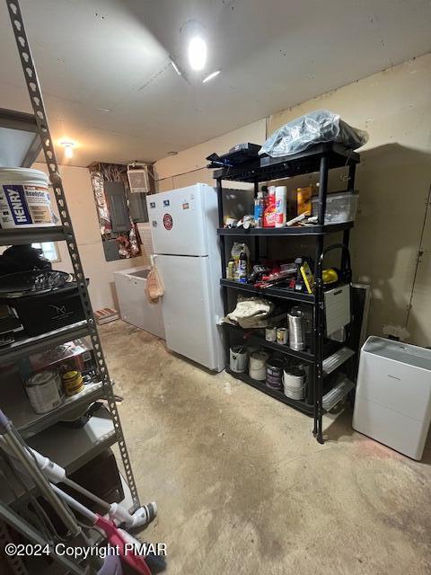 kitchen featuring concrete floors and freestanding refrigerator