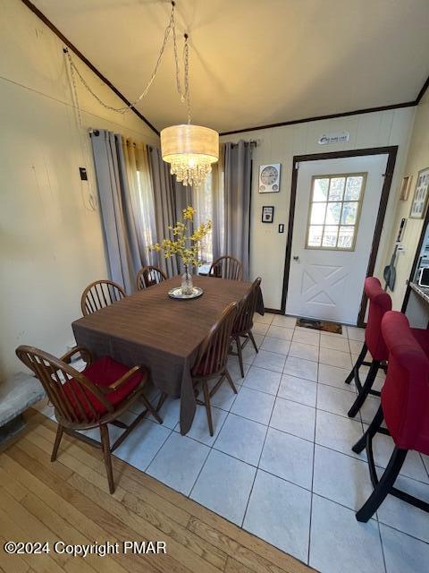 dining area with light wood-style flooring, a chandelier, and crown molding