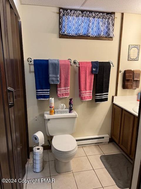 bathroom featuring toilet, vanity, baseboard heating, and tile patterned floors