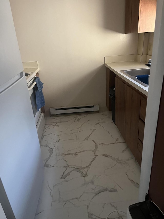 116 Foxfire Dr Unit 105, Mount Pocono, PA 18344 - kitchen featuring a sink, freestanding refrigerator, baseboard heating, marble finish floor, and brown cabinets
