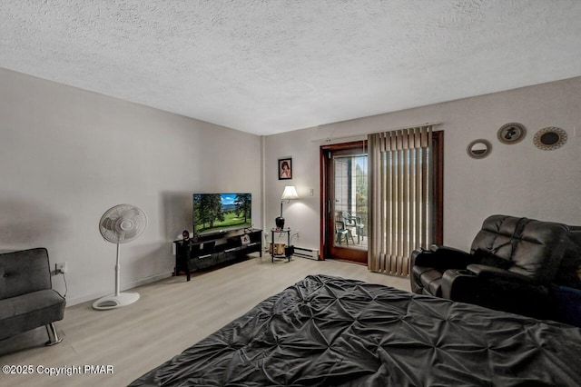 bedroom featuring access to outside, a textured ceiling, wood finished floors, a baseboard radiator, and baseboards