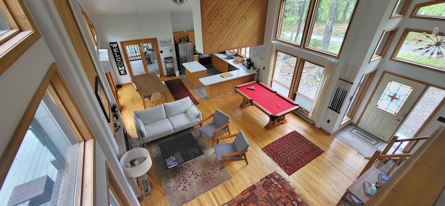living room with a towering ceiling and light wood-style floors
