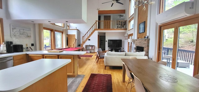 kitchen featuring a high ceiling, open floor plan, healthy amount of natural light, an AC wall unit, and light countertops