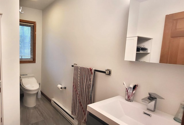 bathroom with baseboard heating, toilet, vanity, and baseboards