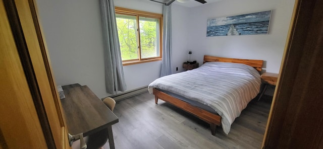 bedroom featuring baseboard heating and wood finished floors