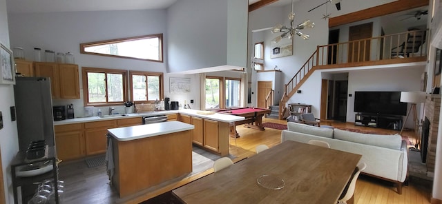 kitchen featuring high vaulted ceiling, stainless steel dishwasher, light countertops, billiards table, and open floor plan
