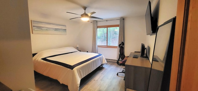 bedroom featuring wood finished floors, a ceiling fan, and a baseboard radiator