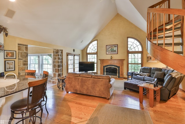 2711 Main St, Bethlehem, PA 18017 - living area with light wood-style floors, high vaulted ceiling, stairway, and a glass covered fireplace