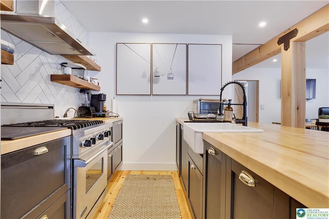 9379 Fairmount Way, Tobyhanna, PA 18466 - kitchen with high end stainless steel range oven, exhaust hood, wood counters, backsplash, and light wood-style floors