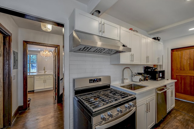 24 Summit Ave, Pocono Summit, PA 18346 - kitchen featuring a sink, appliances with stainless steel finishes, dark wood-style floors, under cabinet range hood, and an inviting chandelier