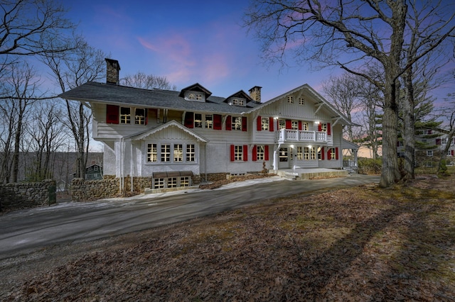24 Summit Ave, Pocono Summit, PA 18346 - view of front of house with a balcony, a porch, driveway, and a chimney