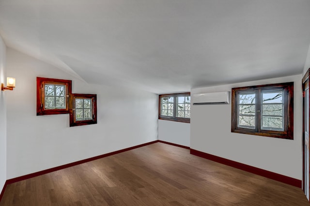 24 Summit Ave, Pocono Summit, PA 18346 - empty room with vaulted ceiling, baseboards, a wall mounted air conditioner, and wood finished floors