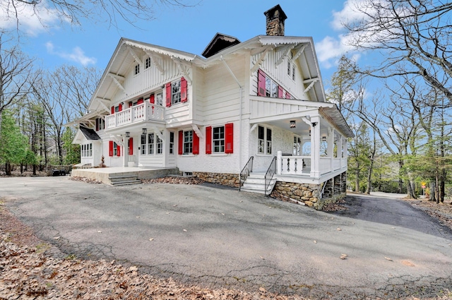 24 Summit Ave, Pocono Summit, PA 18346 - view of side of property with a balcony, a chimney, and a porch