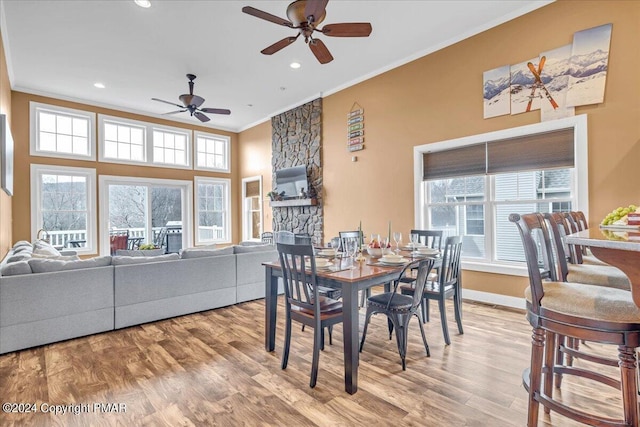 dining area featuring a healthy amount of sunlight, wood finished floors, and crown molding