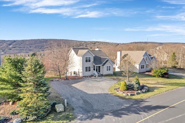 view of front of house with aphalt driveway and a chimney