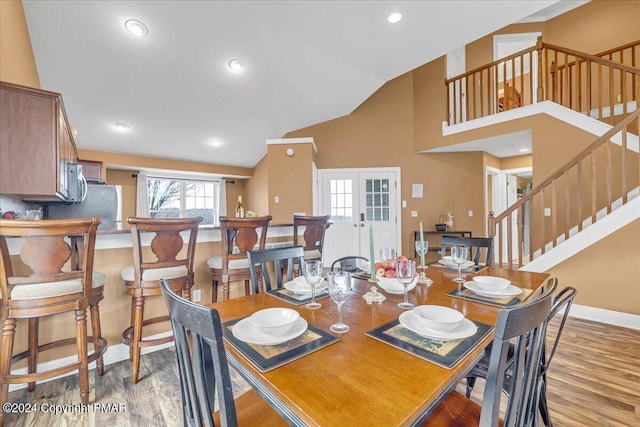 dining room featuring stairway, baseboards, wood finished floors, and french doors